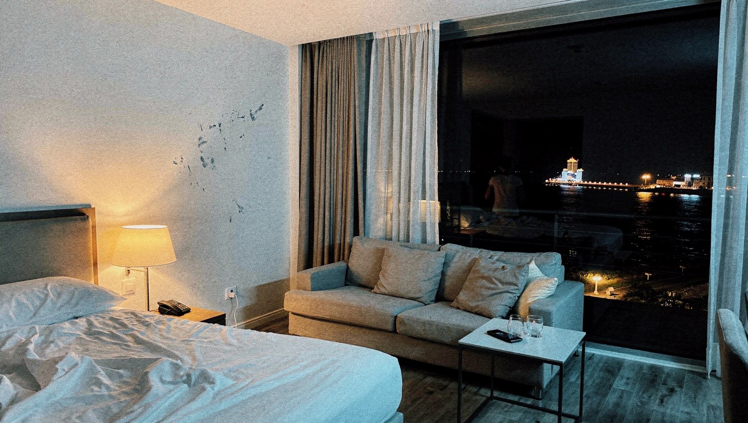 Seafront suite above the sea at night with floor-to-ceiling window