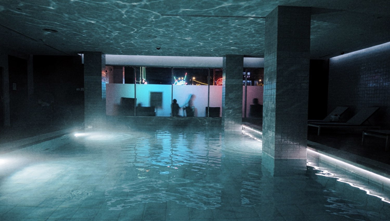 Calm hotel spa at night with cool-blue pool reflection
